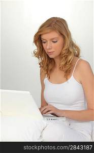 Woman in white with a white laptop