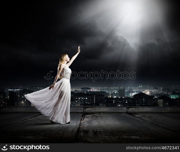 Woman in white. Young woman in white long dress on top of building