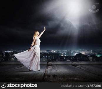Woman in white. Young woman in white long dress on top of building