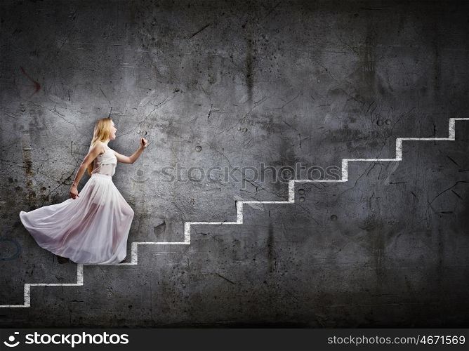 Woman in white. Young woman in white long dress walking up the staircase