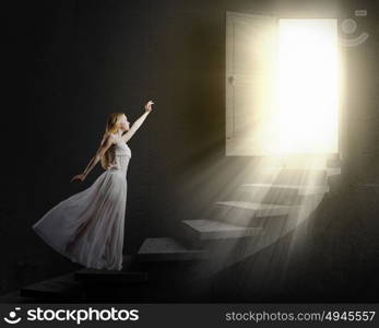 Woman in white. Young woman in white long dress walking up the staircase