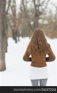 Woman in winter park . rear view