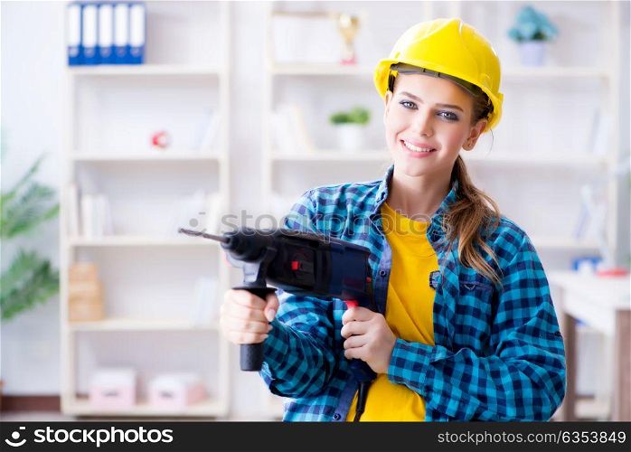 Woman in workshop with drilling drill