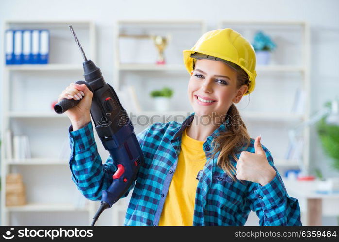 Woman in workshop with drilling drill