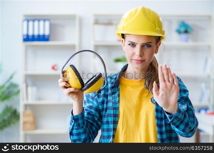 Woman in workshop with noise cancelling headphones. The woman in workshop with noise cancelling headphones