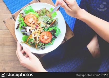 Woman in yoga clothing eating salad, Healthy lifestyle