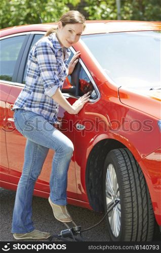 Woman Inflating Car Tyre With Foot Pump