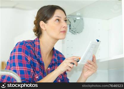 woman inspecting hanging cupboard mechanism