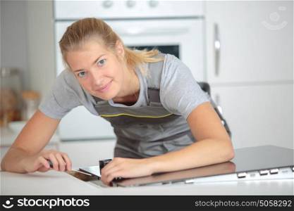 Woman installing hob in kitchen
