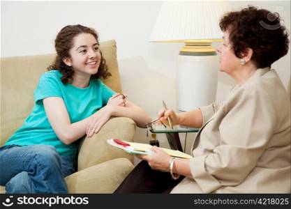 Woman interviewing a teen girl for college admission or job. Could also be counseling session.