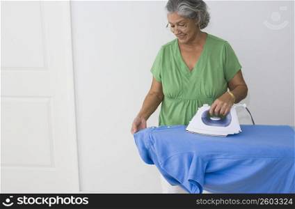 Woman ironing on a polo shirt