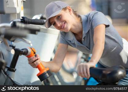 woman is assembling a bike outdoors