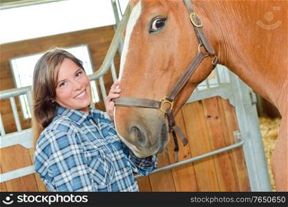 woman is brushing a horse