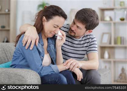 woman is crying while her man is calming her