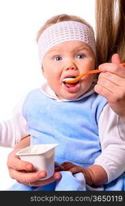 woman is feeding her baby with a spoon