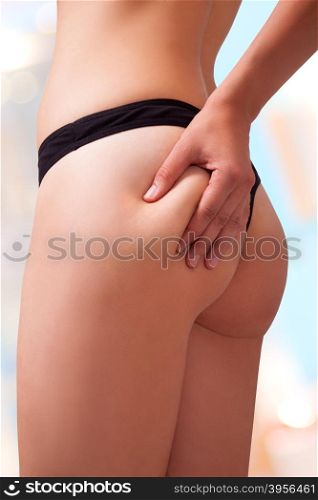 Woman is holding a bit of fats on her butt. Image isolated with work path.