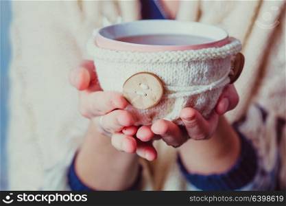 Woman is holding a cup of hot tea. Woman with cup of tea