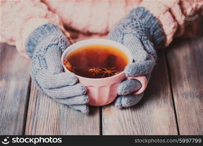 Woman is holding a cup of spicy tea. Woman with cup of tea