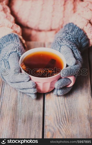 Woman is holding a cup of spicy tea. Woman with cup of tea