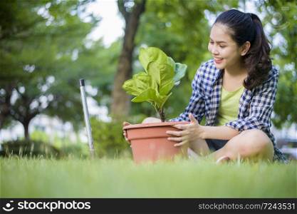 woman is planting the tree in the garden