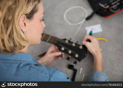 woman is repairing a guitar