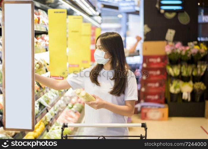 woman is shopping in supermarket with face mask