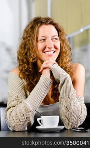 woman is sitting at cafe and smiling