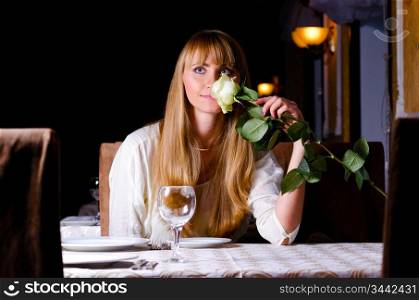 woman is sitting with flower at restaurant