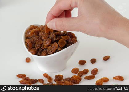 woman is taking raisins from the white bowl.