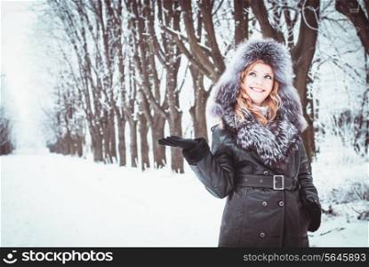 Woman is walking in park alley in winter