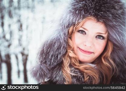 Woman is walking in park alley in winter