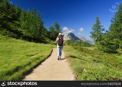 woman is walking on a pathway in Italian Alps