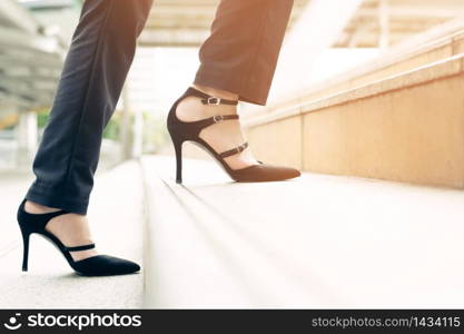 Woman is walking up the stairs outside the building