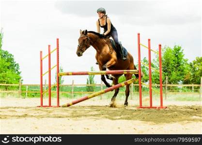 Woman jockey training riding horse. Sport activity. Active woman girl jockey training riding horse jumping over fence. Equestrian sport competition and activity.