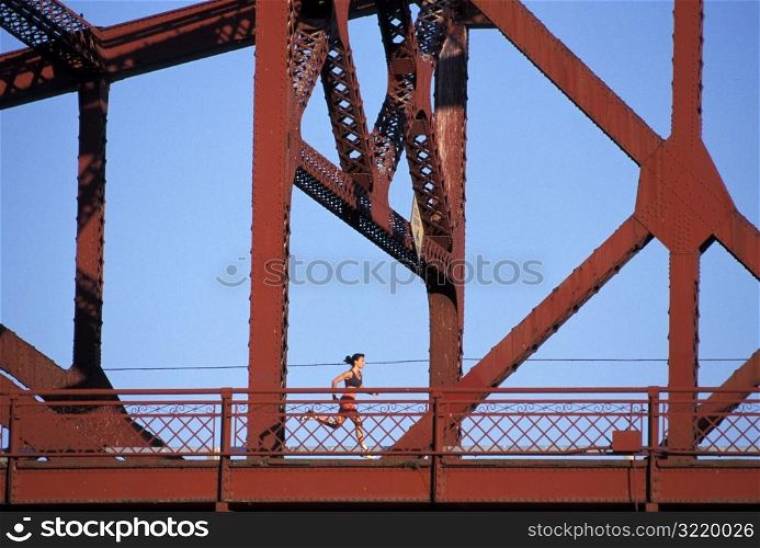 Woman Jogging Across Bridge