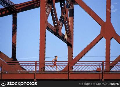 Woman Jogging Across Bridge