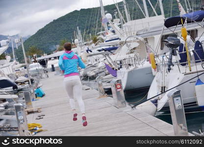 woman jogging at early morning with yacht boats in marina