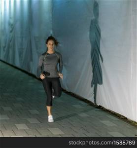 Woman Jogging at Night by the City River. Late Night Jogging in the City