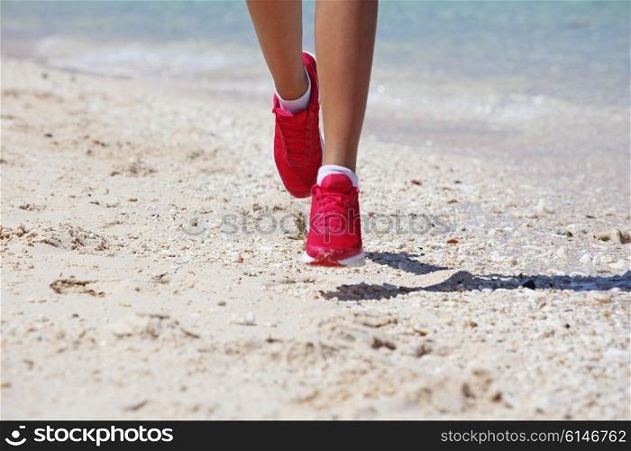 Woman jogging on beach . Close-up view of Running woman feet jogging on beach