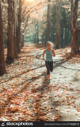 Woman Jogging Outdoors In Autumn in Public Park