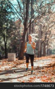 Woman Jogging Outdoors in The Fall, in Public Park