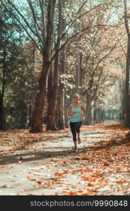 Woman Jogging Outdoors in The Fall, in Public Park