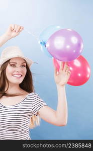 Woman joyful girl playing with colorful balloons. Summer, celebration and lifestyle concept. Studio shot blue background. Woman summer joyful girl with colorful balloons