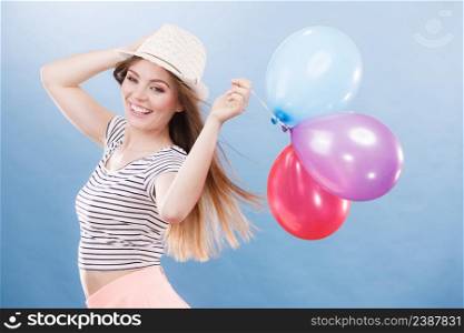 Woman joyful girl playing with colorful balloons. Summer, celebration and lifestyle concept. Studio shot blue background. Woman summer joyful girl with colorful balloons