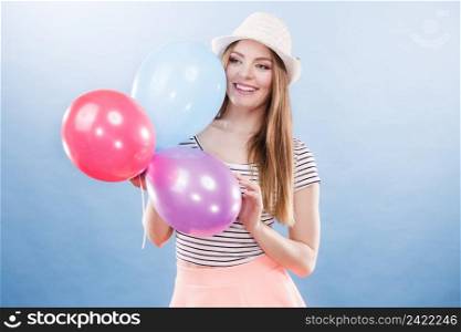 Woman joyful girl playing with colorful balloons. Summer, celebration and lifestyle concept. Studio shot blue background. Woman summer joyful girl with colorful balloons 