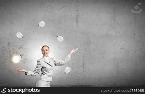 Woman juggler. Young pretty businesswoman juggling with light bulbs