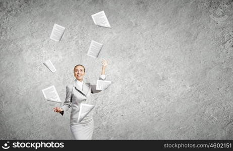 Woman juggler. Young pretty businesswoman juggling with paper sheets