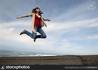 Woman jumping against a blue sky