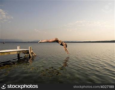 woman jumping from pier