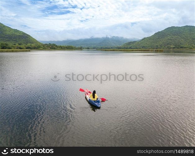 Woman kayaking on lake and mountain in Thailand